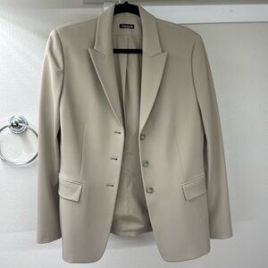 Cream blazer with cinched waist and pockets on the outside & inside